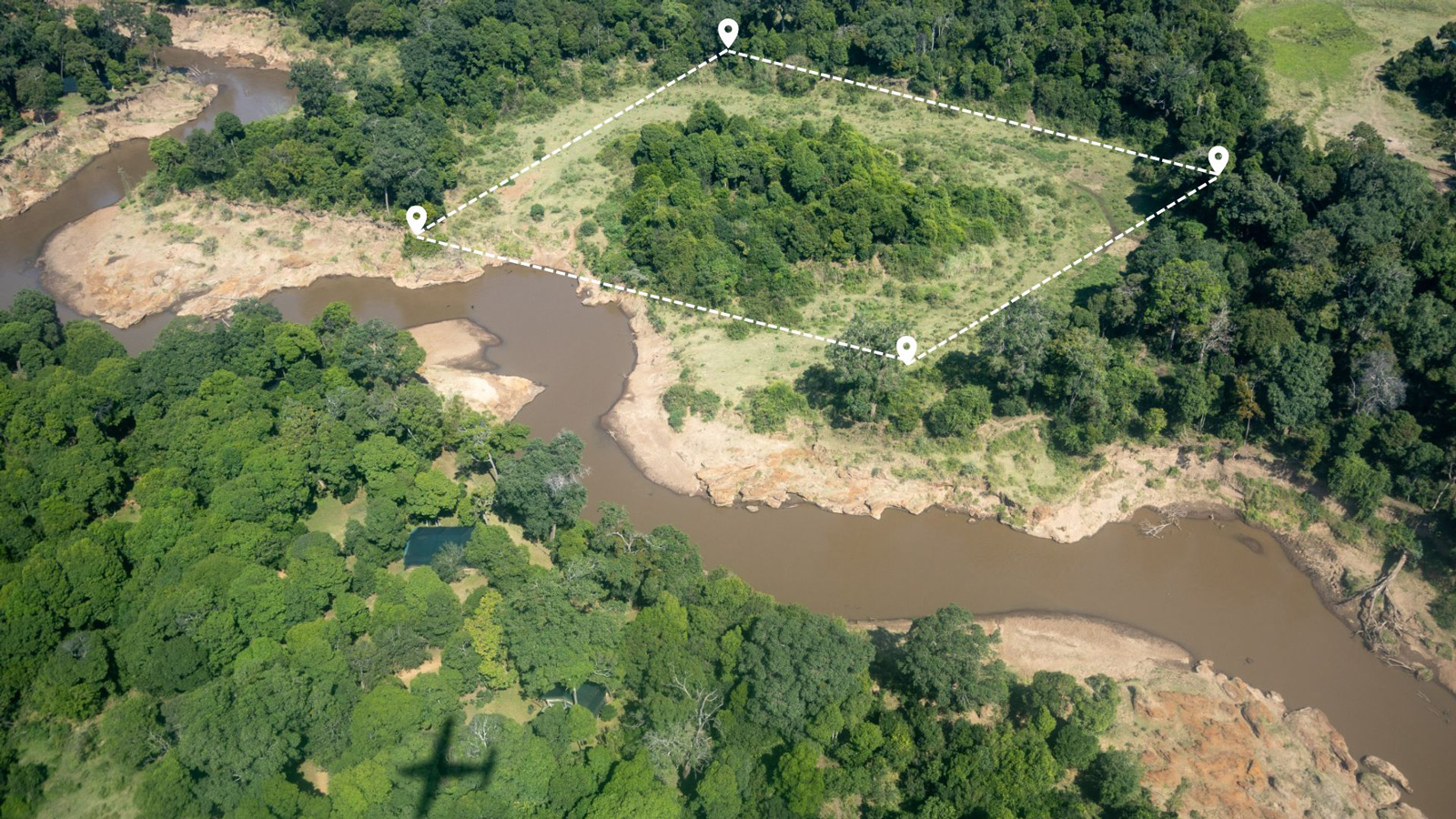 aerial photo showing a land property outline dotted in white on the bank of a river